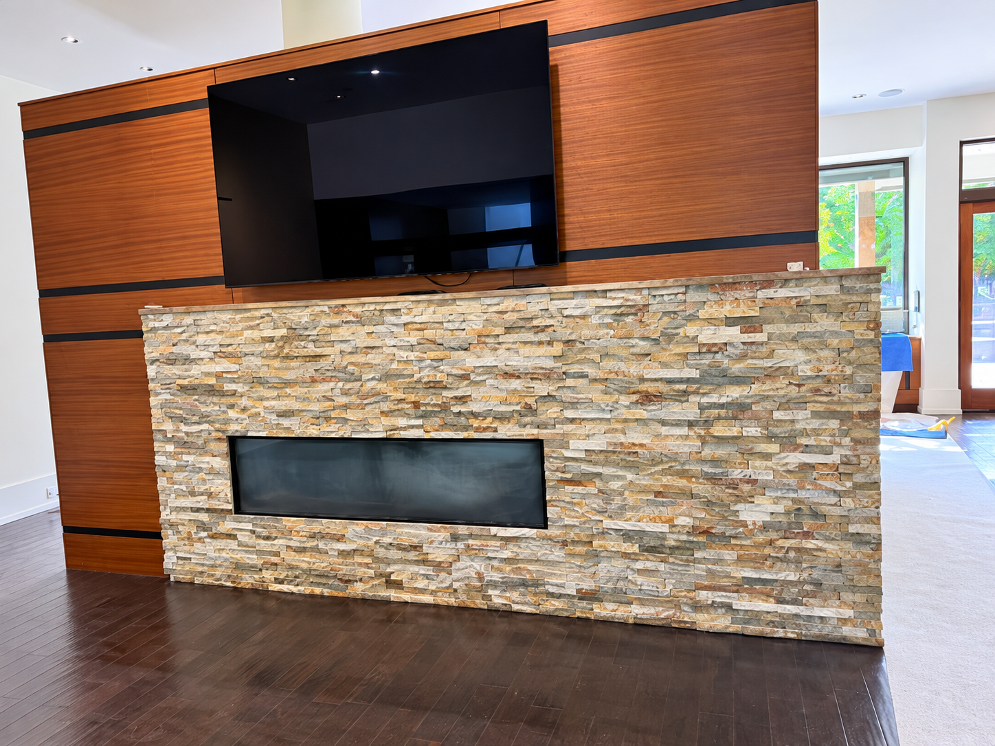 Stone fireplace wall with wood paneling